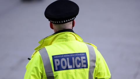 Back of a hi-vis jacket reading 'Greater Manchester Police'.