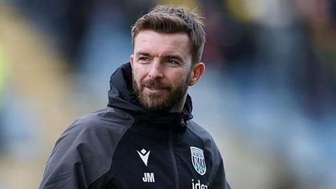 James Morrison is hold a football under his left arm as he takes a training session