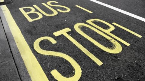 A yellow road marking which says 'bus stop' in capital letters