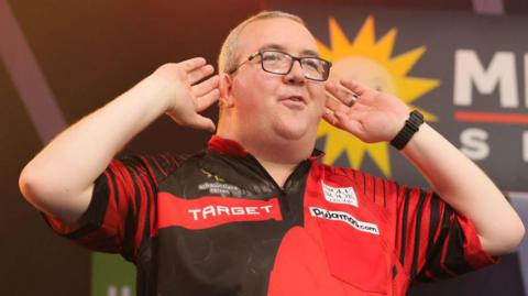 Stephen Bunting cups his hands to his ears 