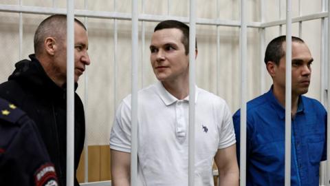 The three lawyers stand behind bars in a courtroom in the town of Petushki in the Vladimir Region of Russia on January 17, 2025