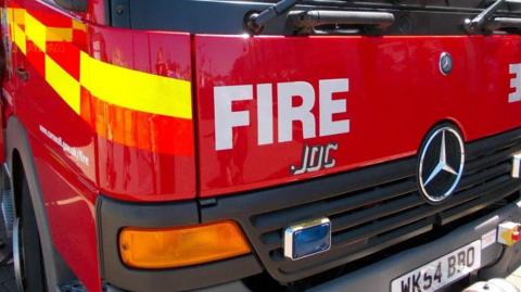 The front of a fire engine showing a bumper, a Mercedes-Benz logo and a number plate which reads WK54 BBO.