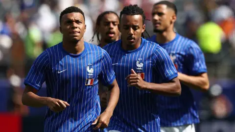 Kylian Mbappe warms up