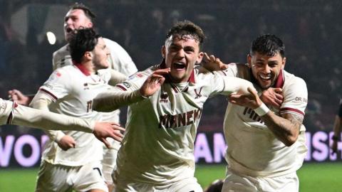 Harrison Burrows is mobbed by his Sheffield United teammates after scoring the winner at Bristol City