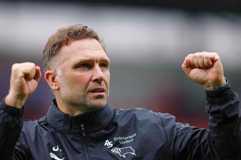 Derby manager John Eustace raises both fists in celebration