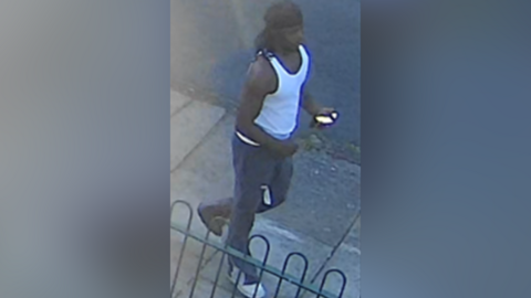 Man walking along with white vest, white trainers and black hair wrap