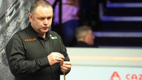 Stephen Maguire chalks his cue