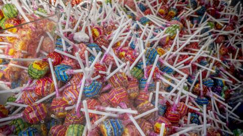 A huge collection of lollipops, all in wrapping of various colours. 