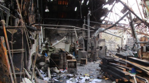 Debris and a collapsed roof can be seen following a fire at an industrial unit