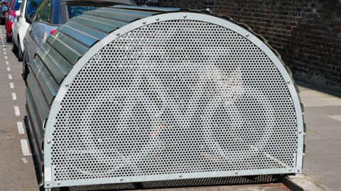 A semi-circular storage unit in an on-street car park space 