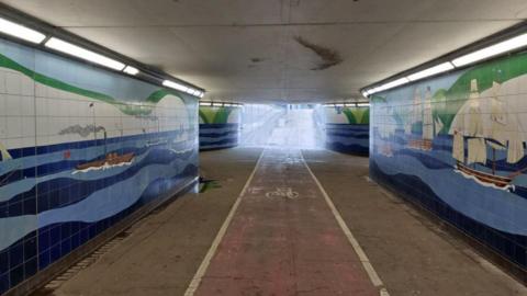 The A20 Townwall Street underpass in Dover, A cycle lane run through it and the walls are tiled blue and display nautical designs.   