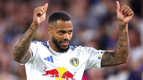 Lukas Nmecha raises two thumbs to the sky
