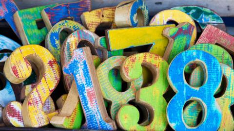 A group of wooden numbers piled up 