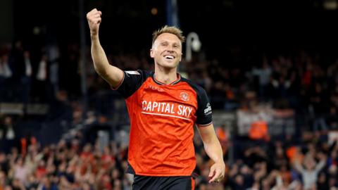 Cauley Woodrow smiles and holds his arm in the air with a fist clenched
