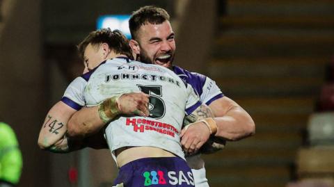Try scorer Tom Johnstone is lifted off the turf in celebration by Wakefield captain Mike McMeeken