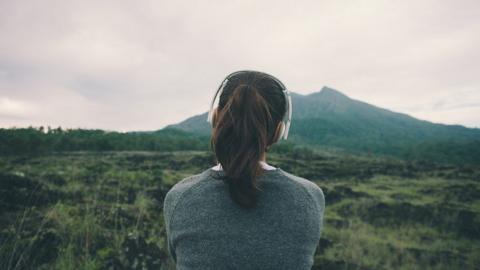 A woman wearing headphones in nature
