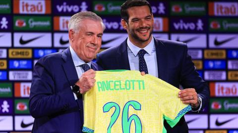 Carlo Ancelotti receives the Brazilian national team shirt from Samir Xaud, the president of the Brazilian Football Confederation (CBF)
