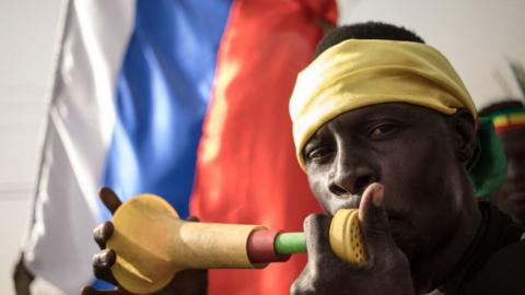 A man plays a vuvuzela at an anti-French, pro-Russian protest in Mali in 2022.