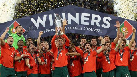 Portugal captain Ronaldo lifting trophy with his teammates around him. 