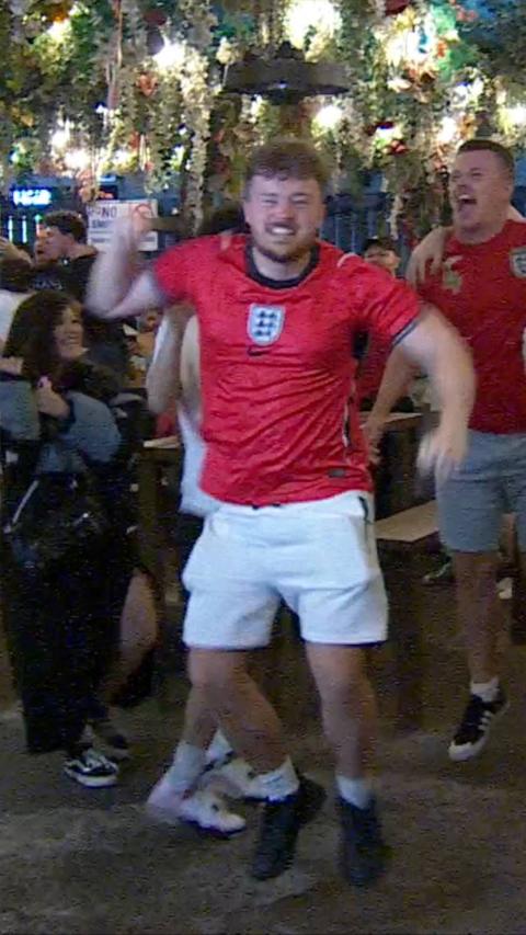 An England fan wearing a red shirt celebrating Harry Kane's match winning penalty.
