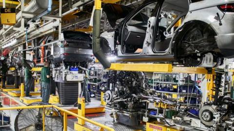 Workers on a car assembly line