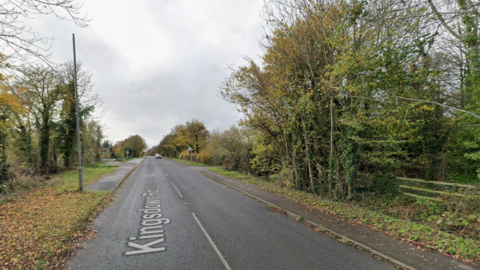 Kingsdown Road in Swindon, with autumnal trees on either side and grey skies.