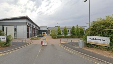 Barriers on the road approaching the Wildwood offices with buildings in the background