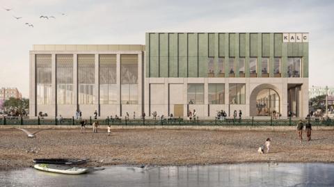 An artist's impression of a large rectangular building with windows on all sides and an arched doorway in the right corner. The letters on the top right of the building read 'KALC'. In front of the building is a beach with the sea in the foreground. There are people on the beach and two kayaks on the edge of the water.