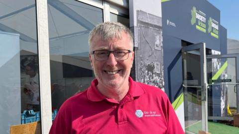 David Gilliand wearing glasses and a red polo shirt