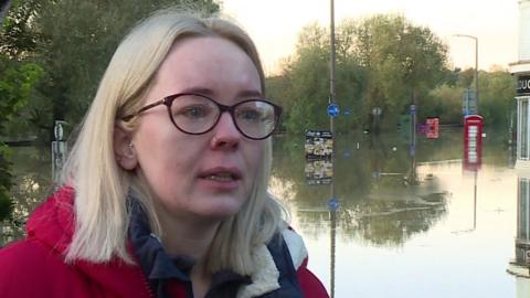 Catcliffe resident Sophie Skidmore with tears in her eye and flood water in the backdrop