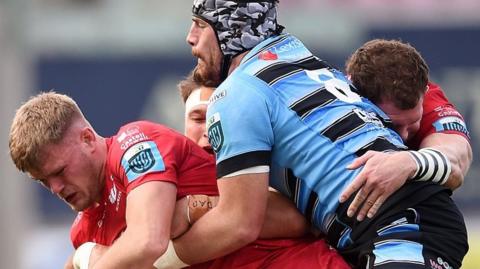 Scarlets' Taine Plumtree is tackled by Cardiff's Alun Lawrence