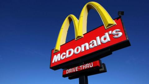 A McDonald's sign against a blue sky