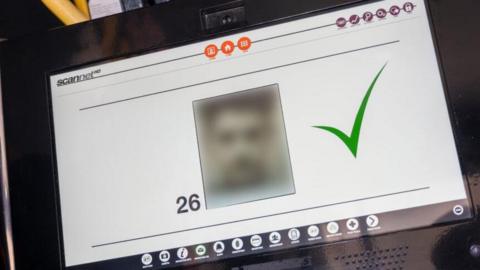 Computer with a screen showing a pixilated face. 