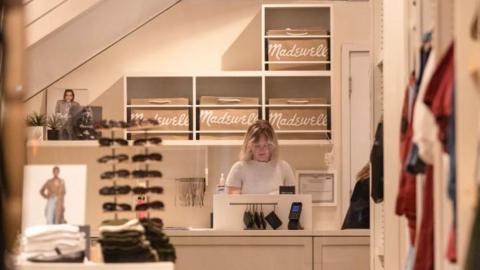 A retail worker at a cash register