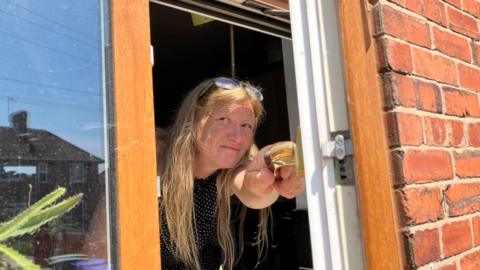 A woman peering out of a window