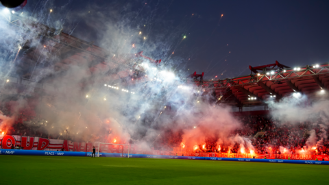 Olympiakos fans light firecrackers before their Champions League match against Freiburg last September