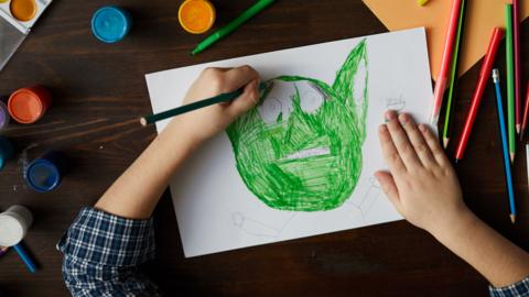 Child drawing monster close-up