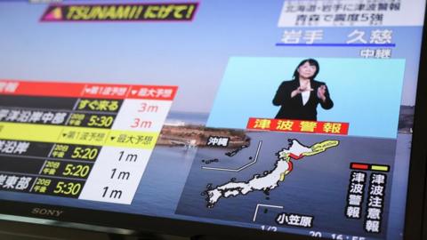 a photo of japanese television showing the tsunami warning.