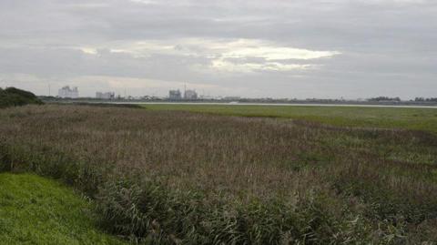 A shot, from a distance, of the former ICI works in Thorton-Cleveleys. It can be seen on the horizon over marsh land.