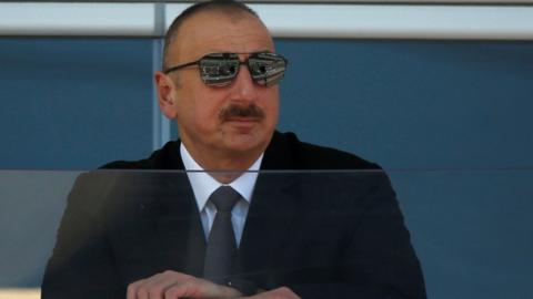 Azerbaijan's President Ilham Aliyev watches a parade in Baku on 25 June