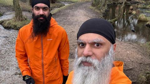 Manny Singh Kang and his son Jeevan wearing orange jackets