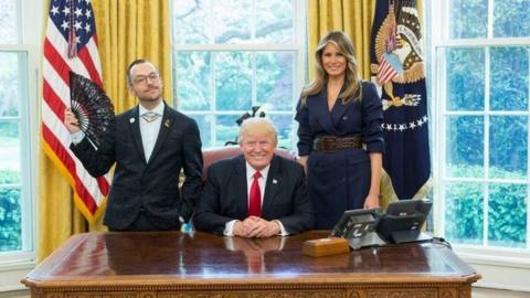 Nikos Giannopoulos with Donald and Melania Trump. and a flag