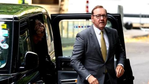 Kevin Spacey getting out of a taxi outside court