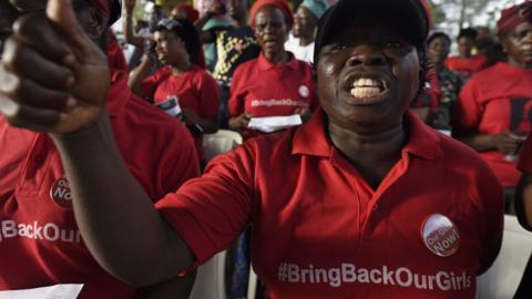 A woman wearing a #BringBackOurGirls t-shirts chants a slogan calling for the release of the remaining 112 kidnapped Chibok schoolgirls during a vigil in Lagos on April 13,