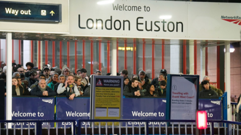 Passengers wait at London Euston station as services disrupted