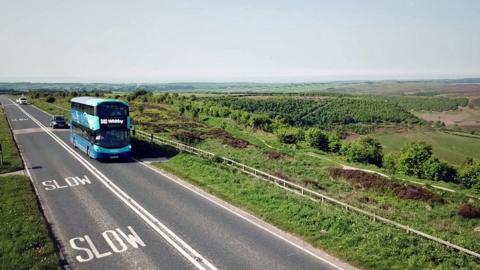 Double-decker bus going through open countryside