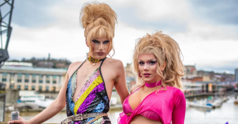 Venus Wailer in pink drag clothes standing in front of Bristol harbourside.