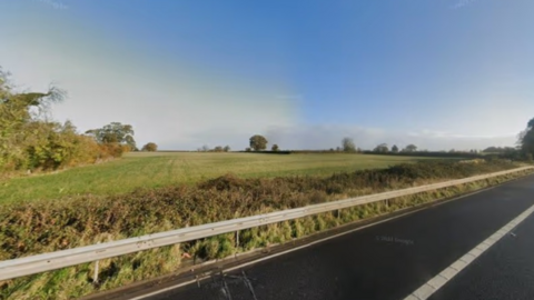 A grassy field by a main road near Chippenham in Wiltshire.