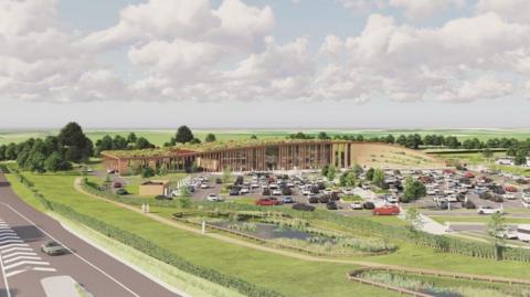 An artist's depiction of a large, modern service‑area–style complex set within a wide, open landscape of grassland and rolling fields. The architecture integrates with the natural environment. The scene is viewed from an elevated angle, giving a broad look at the entire site. The surrounding landscape is open countryside with expansive green fields stretching toward the horizon. The sky is filled with large, soft white clouds scattered across a pale blue background.