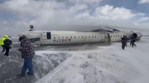 An image taken from a social media video of the plane turned on its roof